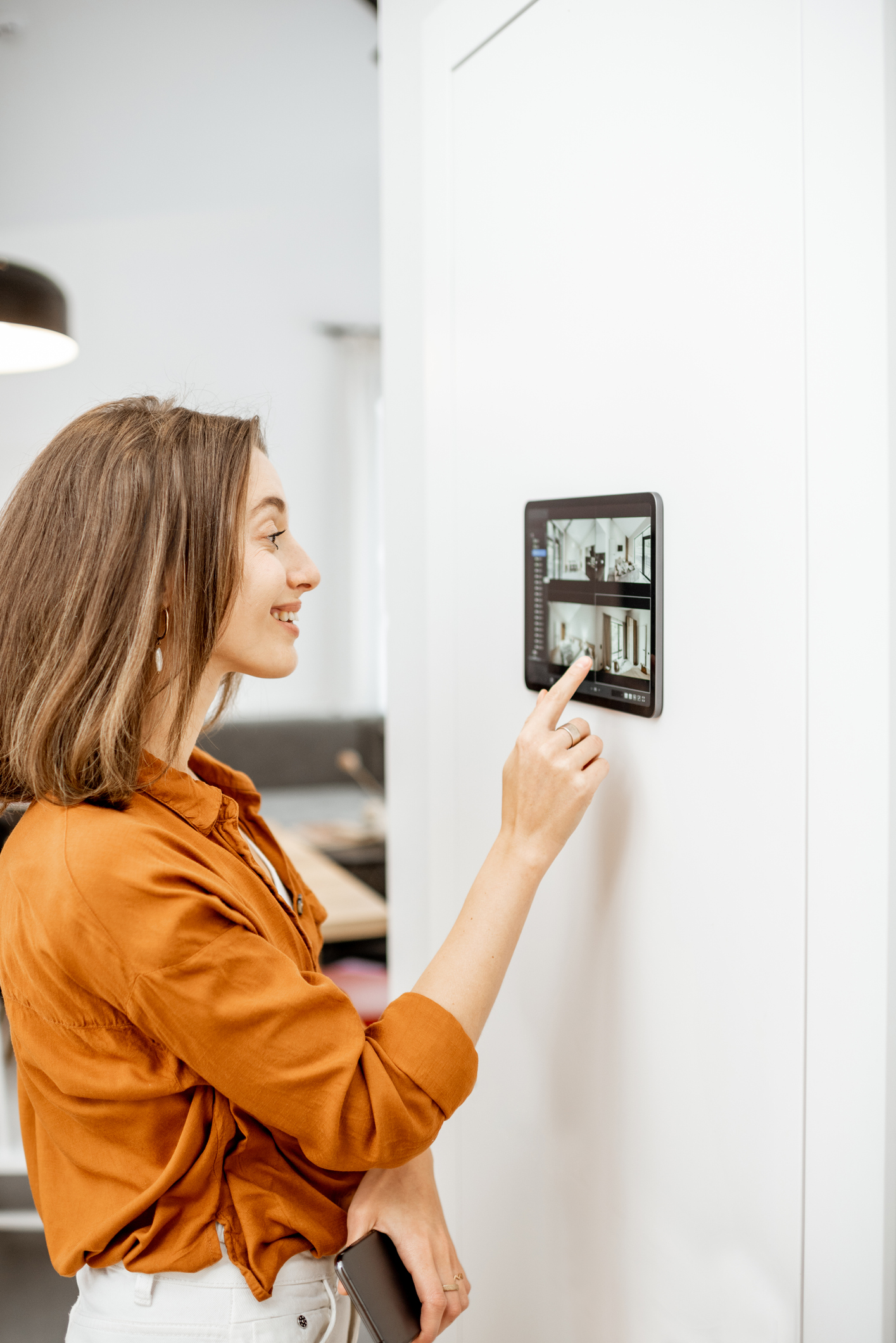 Woman controlling home with video cameras and digital tablet