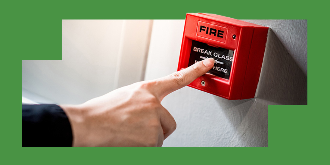 a person pressing a fire break glass button